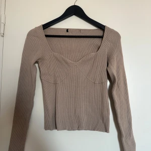 Beige ribbad topp - Beige ribbad topp med långa ärmar och en v-ringad hals. Ingen lapp, använd men fint skick.
