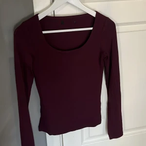 Vinröd långärmad topp - Säljer en stilren vinröd långärmad topp med rund halsringning. Perfekt för höst och vinter, denna topp är både bekväm och snygg. Passar bra till både jeans och kjol.