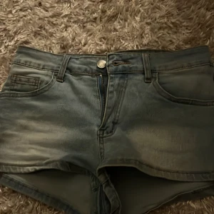 Blå jeansshorts - Snygga blå jeansshorts med klassisk femficksdesign och knapp- och dragkedjestängning. Perfekta för en avslappnad stil. De har en lätt tvättad look som ger en cool vintagekänsla.
