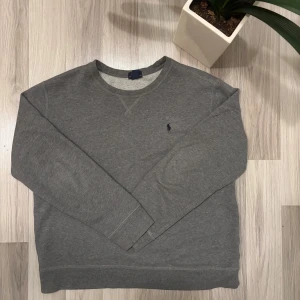 Grå tröja från Polo Ralph Lauren - Tvärfet Ralph lauren tröja. Den har storlek XL men är en mindre modell så den passar som M den är i princip sprillans ny och har inga problem, fläckar osv. Fråga gärna frågor pris kan diskuteras vid snabb och smidig affär.