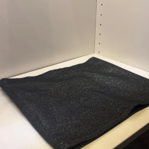 Svart glittrig tube top - Elegant svart tube topp med glittrig yta. Perfekt för att ge en touch av glamour till din outfit. Enkel och stilren design som passar till många tillfällen.