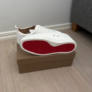 Vita loubs - Snygga vita sneakers från Christian Louboutin med den ikoniska röda sulan. Skorna har en stilren design med snörning och är tillverkade i skinn. Perfekta för en trendig look. Pris kan diskuteras vid snabb affär, vill bara bli av med dom då de var små i storleken