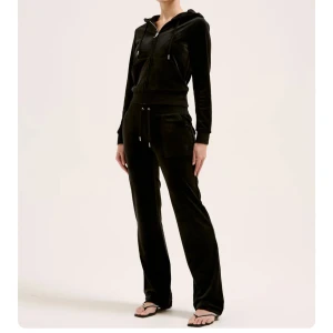 Juciy Couture set  svart L - Snygg och bekväm svart hoodie med dragkedja och långa ärmar. Perfekt för en avslappnad stil. Den har en justerbar huva och praktiska fickor framtill. Kan gå ner i pris vid snabb affär!