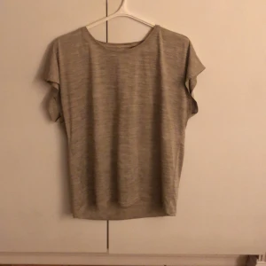 Guldig träningströja från Energetics - Säljer en guldig träningströja från Energetics i storlek M. Tröjan har en enkel design med korta ärmar och är tillverkad i ett lätt och bekvämt material. Perfekt för en avslappnad men stilren träningslook😍