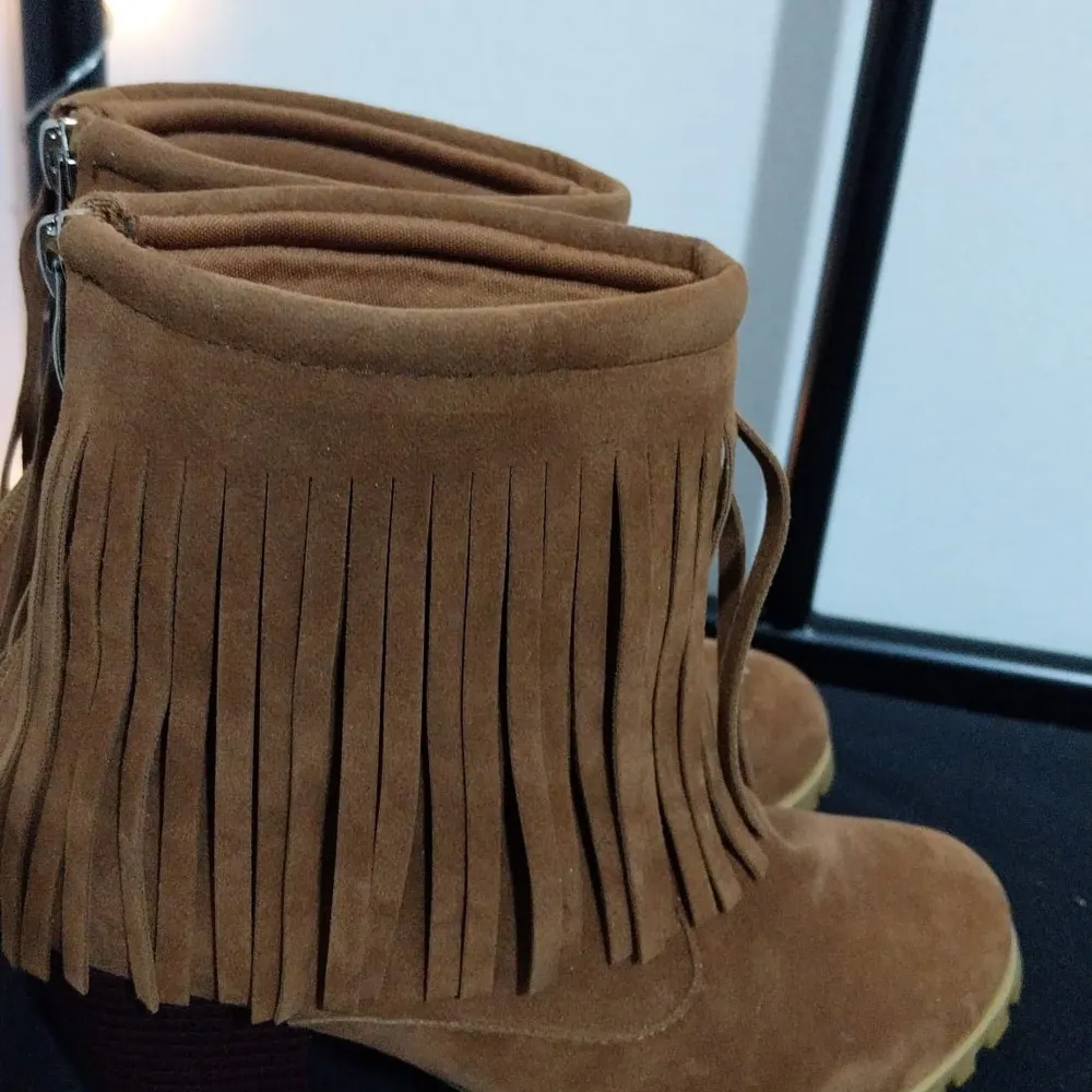 Snygga bruna boots i mocka med fransdetaljer och dragkedja baktill. Perfekta för en bohemisk stil och passar bra till höstgarderoben.. Kengät.