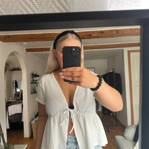 Vit knytblus från Lager 157 - Säljer en söt vit blus från Lager 157 med knytning framtill. Blusen har korta ärmar och en v-ringad design som ger en luftig och somrig känsla. Aldrig använd men har inte lappen kvar. Säljer då jag inte använder den.