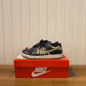 Nike Dunk "Crazy-Camo" - Snygga Nike Dunk sneakers med ett camouflage-mönster i svart, beige och grönt. Köpte dom direkt från Nikes hemsida. Skick är 8/10. Perfekta för dig som vill sticka ut med stil.