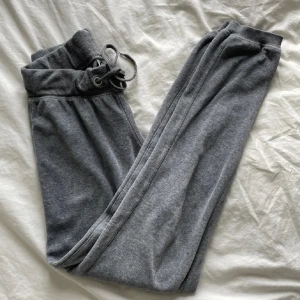 Grå mjukisbyxor med snörning - Säljer ett par grå mjukisbyxor med snörning i midjan. Byxorna har en avslappnad passform och är perfekta för en bekväm dag hemma. De är tillverkade i ett mjukt material som känns skönt mot huden.