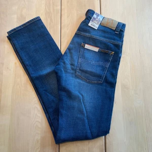 Helt nya Nudie Jeans - Tjena! Säljer nu ett par riktigt feta nudie jeans med en riktigt snygg tvätt. De är HELT NYA, med lapparna fortfarande kvar. Jeansen är i modellen ”Thinn Finn”, vilket är en slim fit passform. De är ju som sagt helt nya, så finns inga defekter. De är i storleken ”32/36”. Hör av er vid närmsta fundering.  ❗️Kolla även in min profil för fler helt nya nudie jeans i olika storlekar❗️