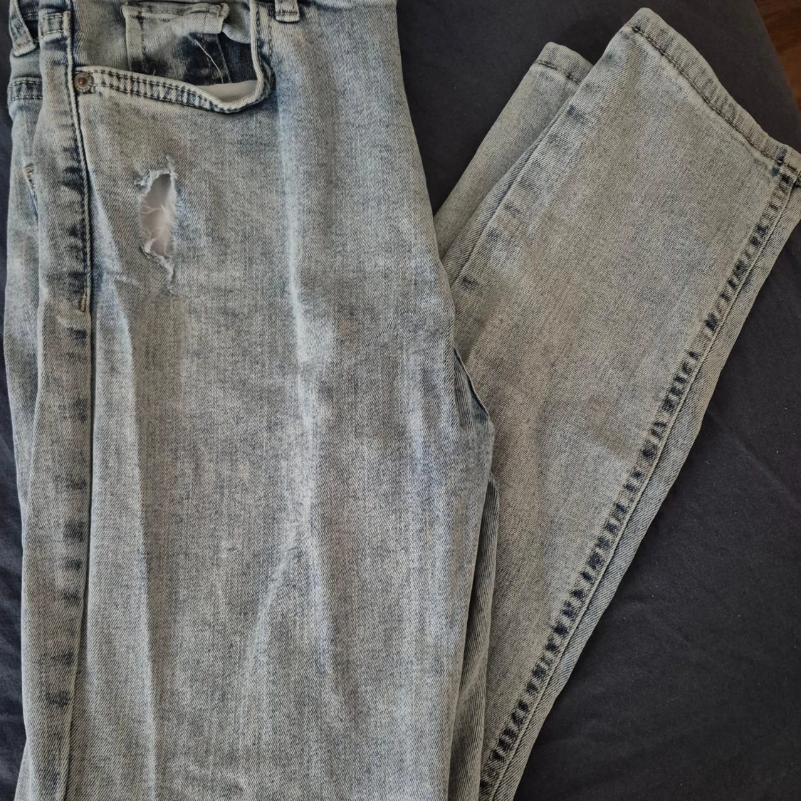 Grå jeans med slitning