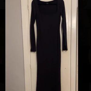 Scart maxi-klänning  - Elegant svart långklänning med långa ärmar och en stilren design. Perfekt för en kväll ute eller en speciell tillställning. Klänningen har en klassisk passform som framhäver figuren.