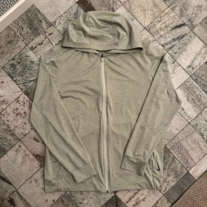 Beige huvtröja från Nike - Säljer en beige huvtröja från Nike med dragkedja och Dri-Fit teknologi. Tröjan har långa ärmar och en praktisk huva. Perfekt för träning eller en avslappnad stil. Nike-loggan är diskret placerad på sidan.