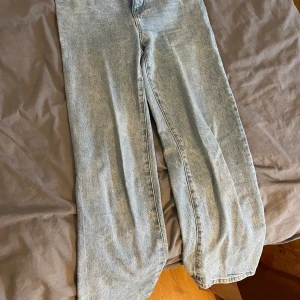 Blå jeans från Lindex - Säljer ett par klassiska blå jeans från Lindex. De har en rak passform och är perfekta för en avslappnad stil. Jeansen har knapp och dragkedja framtill.