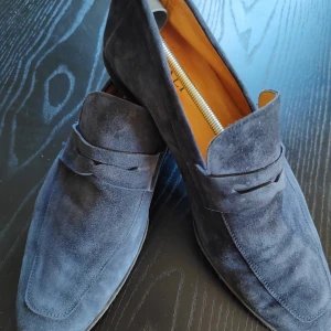 Blå mockaloafers från Canali - Snygga blå loafers i mocka från Canali, tillverkade i Italien. Skorna har en elegant design med en klassisk siluett och en stilren rem över vristen. Perfekta för en stilmedveten look. Mkt fint skick. Inköpta för 4699kr.