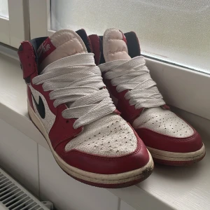Chicago Jordan’s 1 - Snygga Nike Air Jordans i klassisk röd och vit färgkombination med svart swoosh. Skorna har hög snörning och en retro design som alltid är i stil. Perfekta för sneakerheads som älskar en tidlös look. Skorna har jag haft på mig varje dag, men dom går för högt. (Blivit antecknade). Boxen kan jag skicka bild på och allt som kom med skorna. Kom privat för mer information. :)