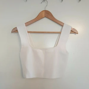 Vit ribbad linnetopp - Säljer en stilren vit ribbad linnetopp från H&M. Toppen har breda axelband och en fyrkantig halsringning, perfekt för en minimalistisk look. Passar bra till både jeans och kjol. 🌟