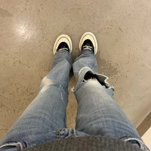 Eytys med vita detaljer - Snygga svarta eytys med vita snören och en tjock vit sula. Skorna har en design med kontrasterande sömmar och en blå rand längs sulan. Väldigt fint skick, skriv vid frågor eller fler bilder. Pris kan diskuteras