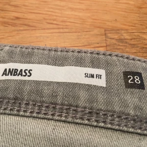 Grå Replay Anbass jeans - Snygga grå Replay Anbass jeans i slim fit. Perfekta för en stilren look med klassisk femficksdesign och bekväm passform. Dessa jeans är tillverkade i ett mjukt material som ger både stil och komfort.