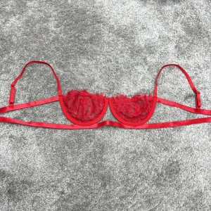 Röd spets-bh - Snygg röd bh med spetsdetaljer och justerbara axelband. Den har en elegant design med tunna band och en delikat spets som ger en feminin touch.