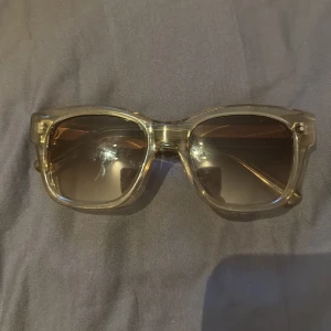 Transparenta solglasögon från Chimi - Snygga transparenta solglasögon från Chimi. Det tillkommer ett vit fodral. Färgen är Ercu och modell 07. Skalmen är lite lös på ena sidan men inget problem när man har dem på sig. Hör av er om ni har frågor, pris kan alltid diskuteras. 