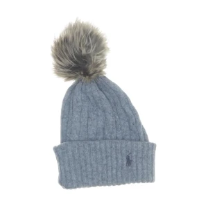 Grå stickad mössa med pälsboll från Ralph Lauren - Snygg grå stickad mössa från Ralph Lauren med en fluffig pälsboll på toppen. Perfekt för att hålla värmen under kyliga dagar. Den ribbade designen ger en skön passform och den klassiska loggan pryder framsidan.