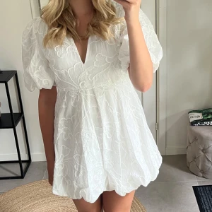 Studentklänning  - Säljer en söt vit klänning från Zara med puffiga korta ärmar och v-ringning. Hade som en av mina studentklänningar. Den va  perfekt!! Inga fläckar som syns. Sista bilden syns lite smink vid axeln men absolut inget märkbart.