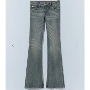 Blå bootcut jeans - Snygga blå bootcut jeans med låg midja och klassisk femficksdesign. Jeansen har en lätt slitning för en cool look och stängs med knapp och dragkedja. Perfekta för en avslappnad stil. I storlek 24/30 men passar mig också  som har 28/30 av nån anledning