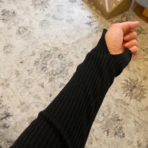 Svart ribbad tröja från H&M  - Säljer en stilren svart ribbad tröja från H&M. Tröjan har en fyrkantig halsringning och långa ärmar, perfekt för en chic look. Passar bra till både jeans och kjol. Aldrig använd, storlek XS, svart tröja från H&M