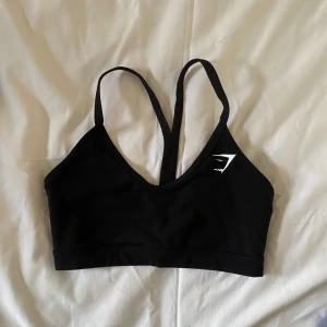 svart sport-bh gymshark - svart sport-bh från gymshark, har inga inlägg i sig utan är endast tyg☺️