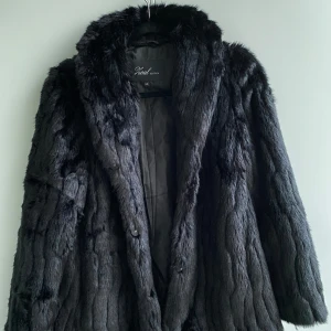 Svart pälsjacka från Zoul - Säljer en supermjuk och lyxig svart fejk-pälsjacka från Zoul. Den är perfekt för kalla vinterdagar och har en elegant design med långa ärmar. Jackan är i storlek XS men är oversized och passar nog M. Sparsamt använd. 🌻🌟🌸