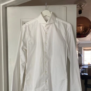 Vit skjorta från Stenströms - Säljer en stilren vit skjorta från Stenströms i modellen Slimline. Skjortan är tillverkad i tvåfaldig superbomull vilket ger en lyxig och mjuk känsla. Den har långa ärmar och knappar framtill. Perfekt för både formella och avslappnade tillfällen.