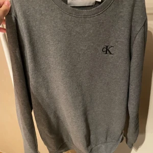 Calvin Klein sweatshirt  - Calvin Klein sweatshirt i grå färg. Skick 8/10. Storlek XS men passar S. Vid funderingar hör av dig.