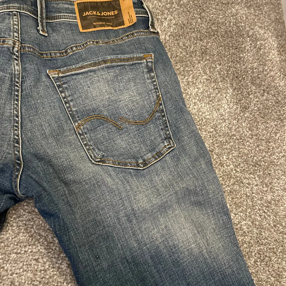 Mörkblåa Jeans från Jack & Jones med slitningar. Knappt använda (nyskick) Storlek 34/32, men de är ”skinny” så sitter som slim för folk med 32/33.. Jeans & Byxor.