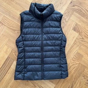 Dunväst - Väst från uniclo i bra skick. Två fickor med dragkedja och två innerfickor.