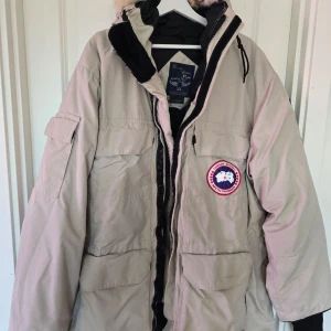 Beige parkajacka från Canada Goose - Säljer en beige parkajacka från Canada Goose med pälsdetaljer på huvan. Jackan är i bra skick då den inte kom till användning, pris kan diskuteras vid snabb affär