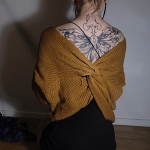 Brun stickad tröja med knytning - Säljer en mysig brun stickad tröja med unik knytning i ryggen. Tröjan har en lös passform och långa ärmar, perfekt för höst och vinter. 