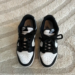 Nike Panda Dunks - Snygga Nike dunk low sneakers med klassisk design.  Köpta 2023 och i mycket bra skick, endast använda ett fåtal gånger. Perfekta till både vardag och streetwear! De är bekväma och passar till många olika outfits.