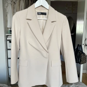 Figursydd kavaj - Jättesnygg kavaj i tight passform med axelvaddar.