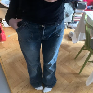 y2k jeans med rimestones - Skitsnygga trendiga vida jeans🪩Vintage bootcut, med stenar/rimestones vid fickorna. Bekväma, jättefin wash! Finns ett litet hål på fickan som lätt går att sy igen (se bild) Dom är stretchiga  Mått Midja: 46cm  Längd: 108cm Benbredd längst ner: 28cm 