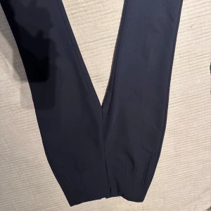 Marinblå kostymbyxor från Zara - Snygga marinblå kostymbyxor från Zara med en stilren design. Byxorna har en dragkedja och knapp framtill för enkel stängning. Perfekta för en elegant look. Passar mig perfekt längdmässigt som är 169 cm lång. 