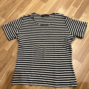 Svartvit randig t-shirt  - Snygg svartvit randig t-shirt från Louiza i storlek L. Den har en klassisk rund hals och korta ärmar. Perfekt för en avslappnad stil.