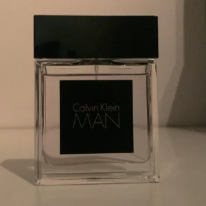 Calvin Klein MAN Eau de Toilette - Säljer en elegant och maskulin doft från Calvin Klein. Flaskan är stilren med en svart fyrkantig design och innehåller 50 ml av doften MAN. Perfekt för den moderna mannen som vill ha en fräsch och sofistikerad doft.