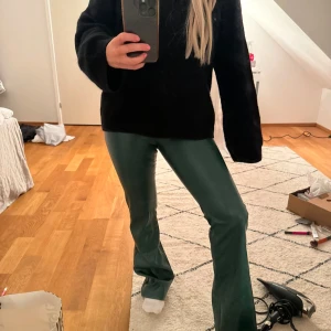 Gröna byxor MadLady XS - Snygga gröna byxor i syntetmaterial med en glansig finish. De har en tight passform och är perfekta för en trendig look. Byxorna är midwaist och har en rak stil som ger en modern touch. Dragkedja sönder men knapp funkar. 