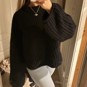 Svart stickad tröja - Mysig svart stickad tröja med långa ärmar och en avslappnad passform. Perfekt för kyliga dagar och enkel att matcha med olika outfits.