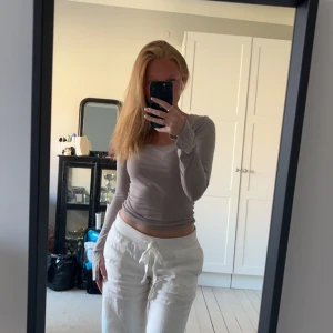 Beige långärmad topp - Säljer en stilren beige långärmad topp med en tight passform. Perfekt för en avslappnad look eller att klä upp med accessoarer. Toppen har en enkel design som gör den lätt att matcha med olika outfits.