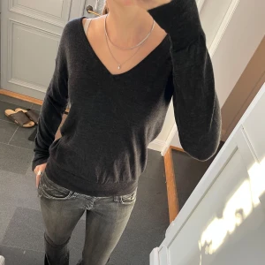 Mörkgrå stickad tröja i Ull - Grå stickad tröja i 100% Ull från Woolmark. Kan inte hitta storlek men skulle säga S/M. Fint skick förutom en liten lagning i ena mudden (sista bilden) men det är inget man tänker på.