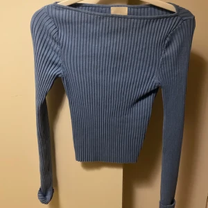 Blå ribbad tröja - Snygg blå ribbad tröja med långärmad design. Perfekt för en stilren look. Tröjan har en enkel och elegant stil som passar till många olika tillfällen.