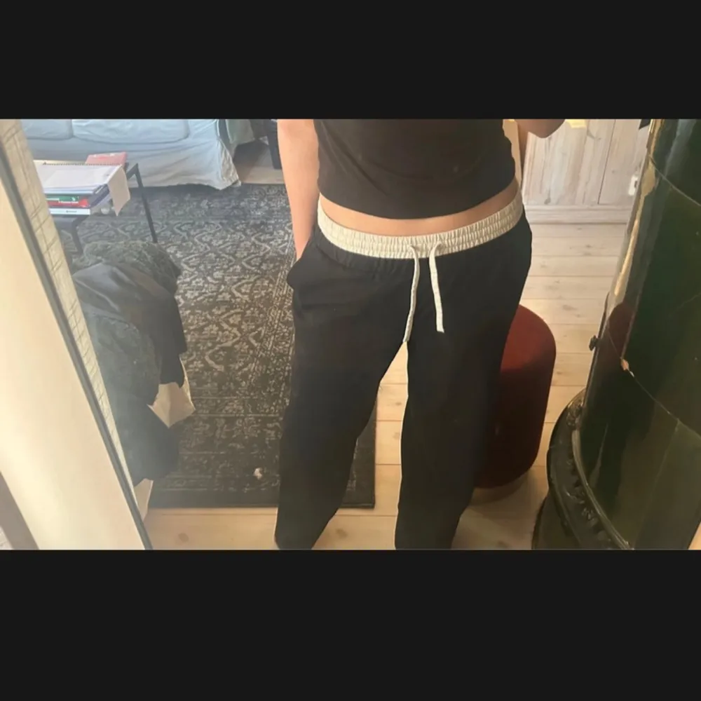 Snygga och bekväma svarta byxor med vit snörning i midjan. Byxorna har en loose passform och är tillverkade i ett mjukt material. Har dock en liten fläck av smink (sista bilden) men annars är dem bara använda vit ett tillfälle.. Farkut & Housut.