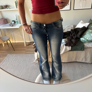 Blå bootcut jeans från Cheap Monday - Snygga blå bootcut jeans från Cheap Monday med en klassisk femficksdesign. De har en låg midja och en lätt slitning för en trendig look. Perfekta för en avslappnad stil.