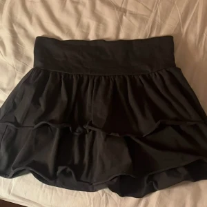 Svart volangkjol från H&M - Snygg svart volangkjol från H&M. Kjolen har en elastisk midja. Inga defekter. Midjemått: 35cm, längd: 34cm men går att vika upp som på bilden. Använd en gång !!💘💘